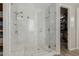 Modern bathroom shower showcases elegant marble tiling, a glass enclosure, and dual shower heads at 6235 S Odessa Dr, Gilbert, AZ 85298