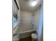 Bright bathtub and shower combo with white tile surround and built in shelving in the bathroom at 6339 W Sophie Ln, Laveen, AZ 85339