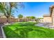 A well-maintained backyard with lush green grass, mature trees, and charming landscaping at 6808 W Angela Dr, Glendale, AZ 85308