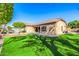 A spacious backyard features artificial grass, an outdoor patio area, and drought-resistant landscaping at 6808 W Angela Dr, Glendale, AZ 85308