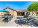 This beautiful backyard features a grill, loungers, patio, and a table with an umbrella on artificial grass at 6808 W Angela Dr, Glendale, AZ 85308