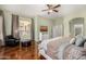 Cozy bedroom with hardwood floors, neutral tones, an accent chair, and a large window with a backyard view at 6808 W Angela Dr, Glendale, AZ 85308
