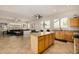 Open floor plan with a kitchen island, granite counters, and stainless appliances flowing into the living space at 6808 W Angela Dr, Glendale, AZ 85308