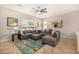 Open living room with a large gray sectional sofa, ceiling fan, and area rug at 6808 W Angela Dr, Glendale, AZ 85308