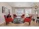 Cozy living area features four red chairs and a round glass coffee table at 6808 W Angela Dr, Glendale, AZ 85308