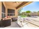 Relaxing covered patio with ceiling fan, outdoor seating, and view of the lush backyard at 6808 W Angela Dr, Glendale, AZ 85308