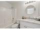 Bathroom featuring a tub and shower combo, a white vanity, and a circular mirror at 7500 E Deer Valley Rd # 132, Scottsdale, AZ 85255