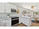 Stylish kitchen featuring white cabinets, marble counters, and wood floors at 7500 E Deer Valley Rd # 132, Scottsdale, AZ 85255
