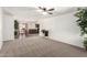 Spacious living room with neutral carpeting, ceiling fan, and open floorplan leading to dining and kitchen at 815 W El Prado Rd, Chandler, AZ 85225