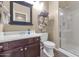 Bright bathroom featuring a dark wood vanity, mirror, decorative towel rack, and glass shower at 8210 W Wethersfield Rd, Peoria, AZ 85381