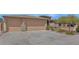Spacious three-car garage with an extended driveway and desert landscaping at 8210 W Wethersfield Rd, Peoria, AZ 85381