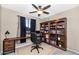 Inviting home office features a built-in bookshelf, desk, computer, and comfortable chair at 8210 W Wethersfield Rd, Peoria, AZ 85381