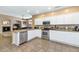 Spacious kitchen with stainless steel appliances, white cabinets, and a view into the living room at 8210 W Wethersfield Rd, Peoria, AZ 85381