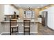 Bright kitchen featuring white cabinetry, stainless appliances, and a breakfast bar with seating at 8210 W Wethersfield Rd, Peoria, AZ 85381