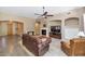 Open living room with a fireplace, tile floors, and views of the front and back yards at 8210 W Wethersfield Rd, Peoria, AZ 85381