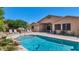 Backyard oasis featuring a refreshing pool, outdoor seating, lush greenery, and desert landscaping at 8210 W Wethersfield Rd, Peoria, AZ 85381