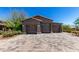 A three-car garage stands at the end of a paved driveway, showcasing the building's wooden details at 8555 E Tecolote Cir, Scottsdale, AZ 85266