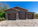Detached three car garage with wood siding, tile roof, and paved driveway offers ample parking at 8555 E Tecolote Cir, Scottsdale, AZ 85266