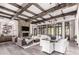 An open-concept living room with wood beams, fireplace, and large windows offers luxurious comfort at 8555 E Tecolote Cir, Scottsdale, AZ 85266