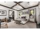 Bedroom with a tufted headboard, wood beam ceilings, hardwood floors and picture frame windows at 8555 E Tecolote Cir, Scottsdale, AZ 85266