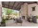 Covered patio has an outdoor fireplace, seating area, and landscaping for cozy, outdoor living at 8555 E Tecolote Cir, Scottsdale, AZ 85266