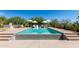 Stunning pool with integrated tanning ledge, surrounded by lush landscaping and comfortable lounge seating at 8555 E Tecolote Cir, Scottsdale, AZ 85266