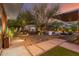 Stunning backyard with stone pathway, mature trees, ambient lighting, and inviting outdoor seating, creating a serene escape at 9502 N 47Th St, Phoenix, AZ 85028