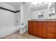 Well-lit bathroom with a combined tub and shower and wooden vanity with storage at 9820 N Central Ave # 303, Phoenix, AZ 85020