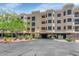 The front exterior of this multi-story condo features covered parking, mature landscaping, and a stucco facade at 9820 N Central Ave # 303, Phoenix, AZ 85020
