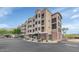 The front exterior of this multi-story condo features a gated entrance, desert landscaping, and a stucco facade at 9820 N Central Ave # 303, Phoenix, AZ 85020