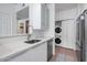 Functional kitchenette featuring a dishwasher and stackable washer/dryer units at 9820 N Central Ave # 303, Phoenix, AZ 85020