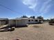 Exterior home view featuring gravel yard, white exterior, solar panels, and covered patio at 10728 W El Rancho Dr, Sun City, AZ 85351