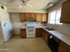 Well-lit kitchen with ample cabinet space, standard appliances, and large window at 10728 W El Rancho Dr, Sun City, AZ 85351