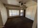 Comfortable living room with large window, ceiling fan, and convenient side door access at 10728 W El Rancho Dr, Sun City, AZ 85351