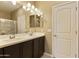 Bathroom with double vanity, dark cabinets, and framed mirror, with a step-in shower behind the sink at 1367 S Country Club Dr # 1167, Mesa, AZ 85210