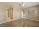 View of the bedroom with carpeted floors, neutral walls, ceiling fan and arched doorway to tiled hallway at 1367 S Country Club Dr # 1167, Mesa, AZ 85210