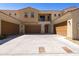 Beige two-story home with brown garages, balcony, and a spacious concrete driveway at 1367 S Country Club Dr # 1167, Mesa, AZ 85210