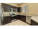 Modern kitchen with stainless steel appliances, dark wood cabinets, and granite counters at 1367 S Country Club Dr # 1167, Mesa, AZ 85210