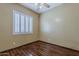 Comfortable bedroom with wood floors, ceiling fan, and bright window with plantation shutters at 1391 W Windhaven Ave, Gilbert, AZ 85233