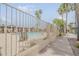 Gated community pool with lounge chairs, lots of palm trees and green landscaping surrounding the space at 1391 W Windhaven Ave, Gilbert, AZ 85233