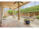 Relaxing covered patio area with ceiling fans overlooking the yard, fencing, and lavish landscaping around the pool at 1391 W Windhaven Ave, Gilbert, AZ 85233