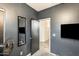 Gray bedroom with a full length mirror, door way, and a wall mounted TV at 14752 W Evans Dr, Surprise, AZ 85379