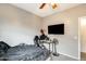 A bedroom with a ceiling fan, desk, tv, and a closet for storage at 14752 W Evans Dr, Surprise, AZ 85379
