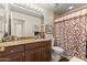 Well-maintained bathroom featuring granite countertops, vanity lighting, and a patterned shower curtain at 15011 S 27Th Pl, Phoenix, AZ 85048