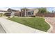 Single-story home features a large manicured lawn with desert landscaping and a neutral color palette at 15011 S 27Th Pl, Phoenix, AZ 85048