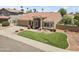 A well-maintained single-story home with desert landscaping, a lush green lawn and a spacious driveway at 15011 S 27Th Pl, Phoenix, AZ 85048