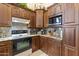 Well-equipped kitchen featuring granite counters, wood cabinets, and modern appliances at 15011 S 27Th Pl, Phoenix, AZ 85048