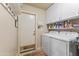 Functional laundry room with a side-by-side washer and dryer, white cabinetry and convenient door access at 15011 S 27Th Pl, Phoenix, AZ 85048