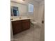 Bright bathroom with dark wood vanity, and a shower-tub combo at 15446 W Jenan Dr, Surprise, AZ 85379