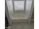 A relaxing bathtub with tiled floor and a window for natural light at 15446 W Jenan Dr, Surprise, AZ 85379